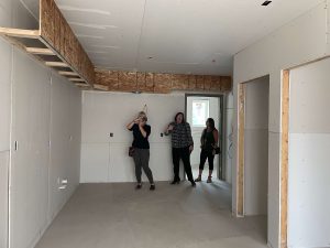 women taking photos of room under construction